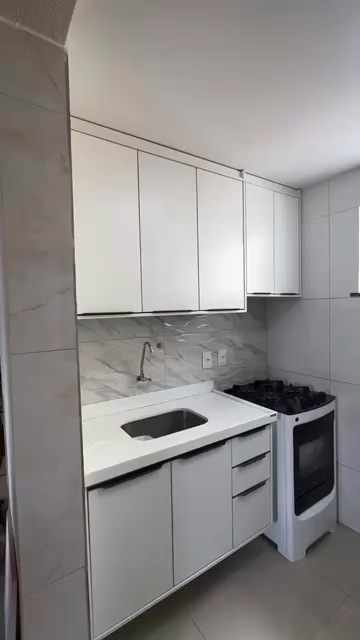 Armário de cozinha na cor branco tx com detalhe dos puxadores facetados bronze.